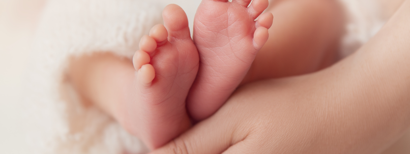 Newborn baby's feet on Mum's hand