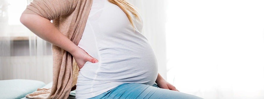 Pregnant woman holding her back