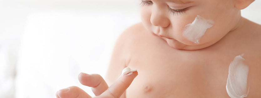 Baby being given suncream