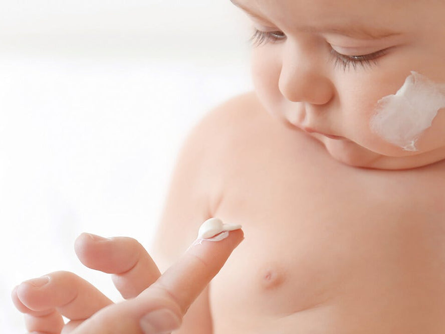 Baby being given suncream