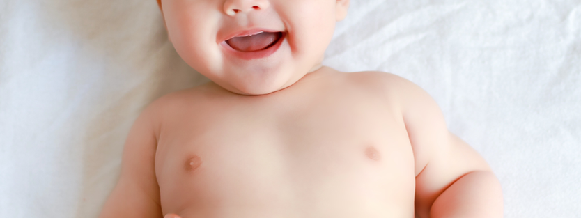 Baby laughing on a bed