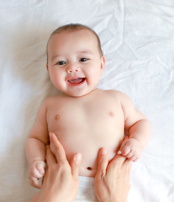 Baby laughing on a bed