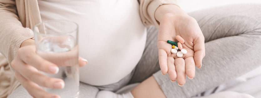 Pregnant woman holding vitamins