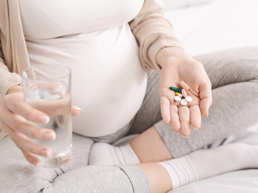 Pregnant woman holding vitamins