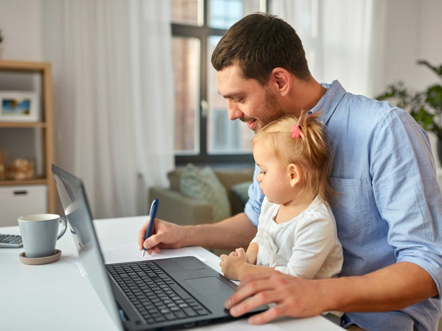 man doing work on bench with toddler