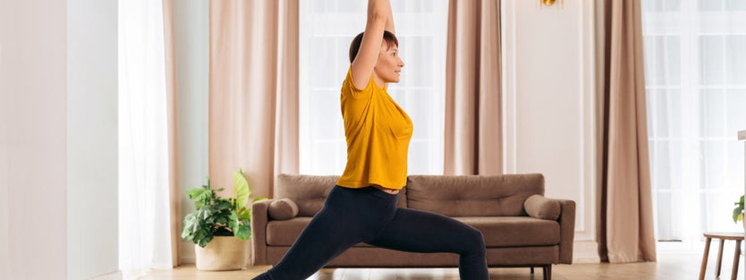 Woman standing on a yoga pose with baby under her legs