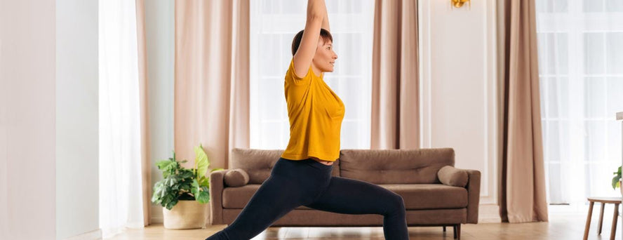 Woman standing on a yoga pose with baby under her legs