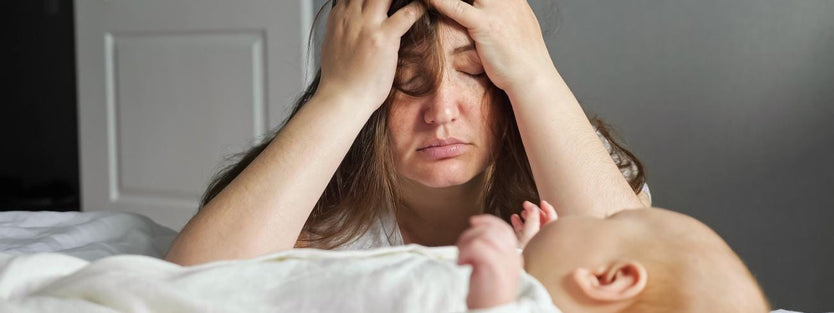 Tired mother in front of crying baby