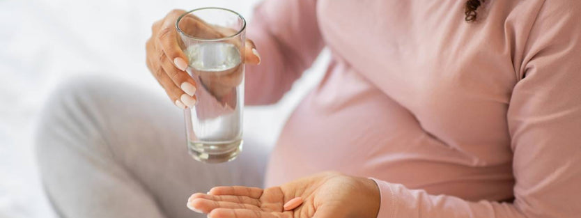 Pregnant woman taking folic acid supplement