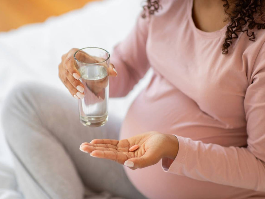 Pregnant woman taking folic acid supplement