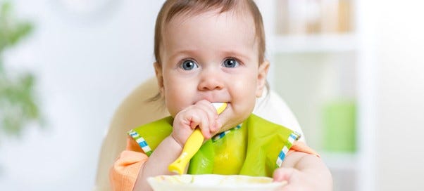 baby eating in highchair