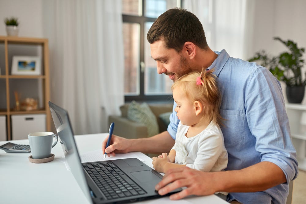 man doing work on bench with toddler