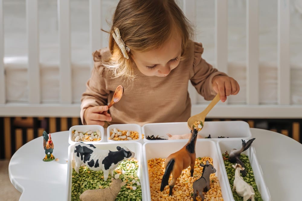 child playing with seeds and legumes