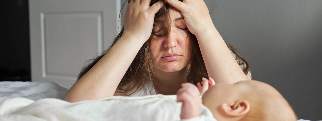 Tired mother in front of crying baby