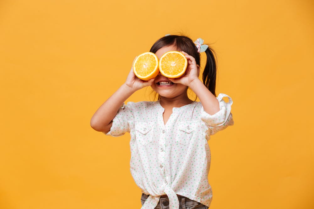 toddler eating orange